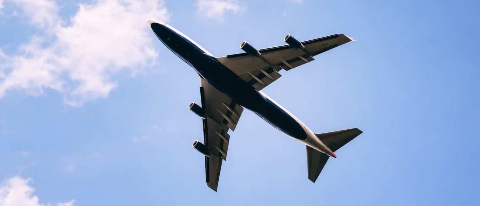 Wide-body airliner climbing through a blue sky
